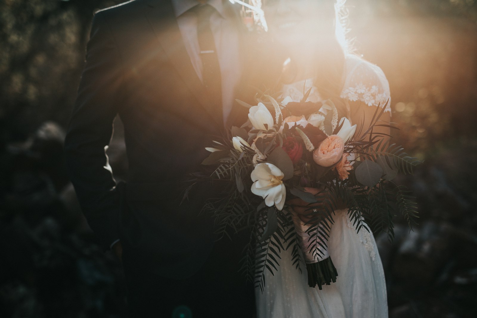 The couple with their bouquet, at sunset