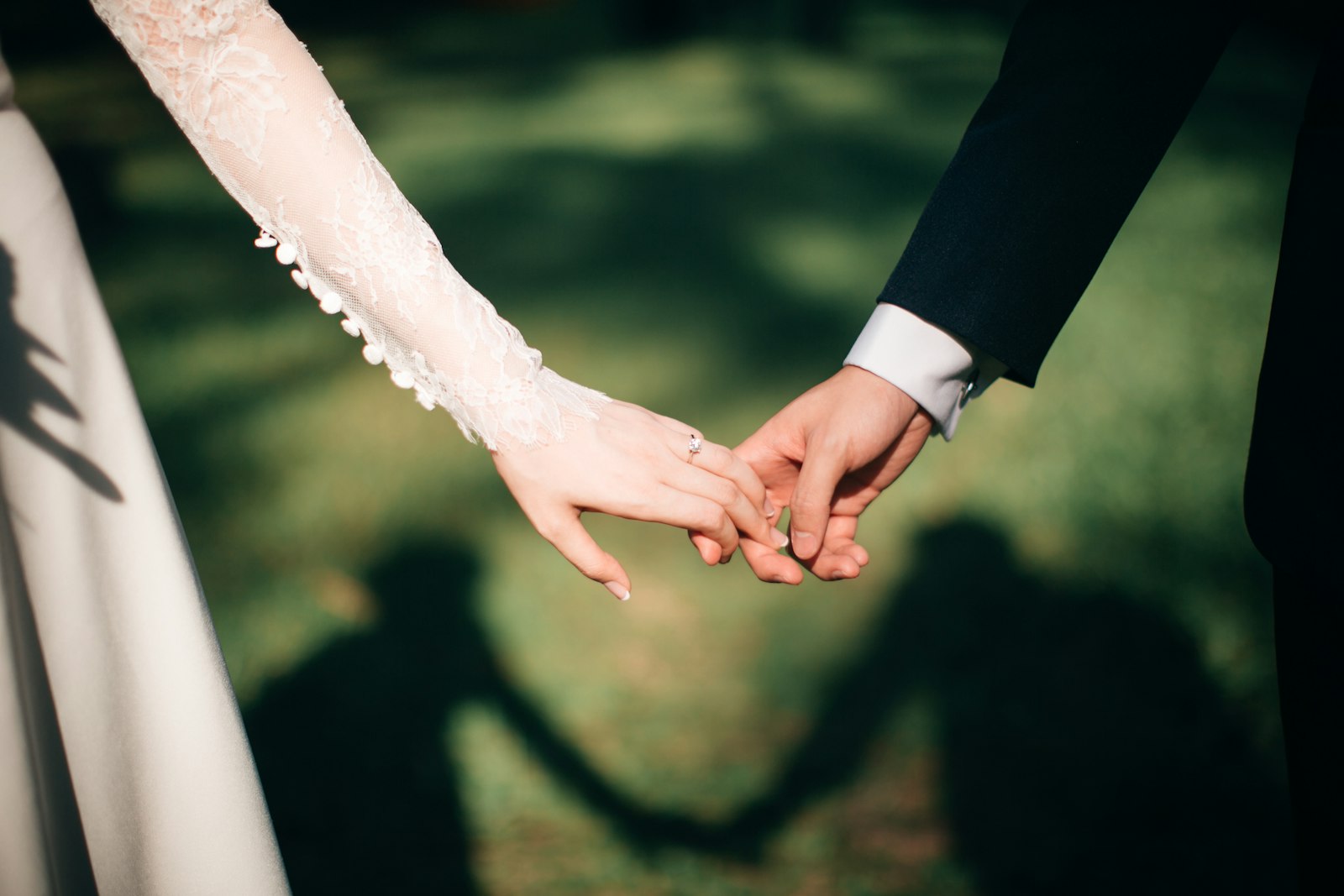 The couple hand in hand at sunset, seen by their photographer